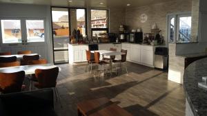 a kitchen with white cabinets and tables and chairs at Super 8 by Wyndham Wendover in Wendover