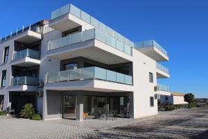 a white building with glass balconies on it at Apartmani Uwe in Banjole