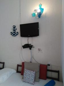 TV at/o entertainment center sa Apartamento Studio ao Lado da Praia com Wi-Fi e TV Smart