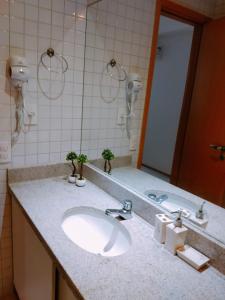 y baño con lavabo y espejo. en Fantástico Flat 02 qts Nui Supreme, en Porto de Galinhas