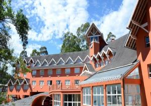 a large orange building with a clock tower at Hotel Renascença in Gramado