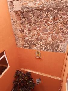 a stone wall with a clock on the side of a building at Hotel Meson Mariano Matamoros in Querétaro