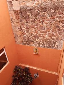a stone wall with a clock on the side of a building at Hotel Meson Mariano Matamoros in Querétaro +13 photos