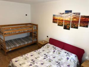 a bedroom with a bunk bed and paintings on the wall at Villa del Sol in Zoagli