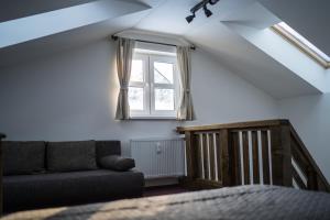 Una sala de estar con un sofá y una ventana. en Apartmány Biela Púť - Jasná, en Demänovská Dolina