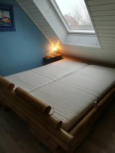 ネスマージールにあるFEWO "KIRA" Neßmersielの窓付きの部屋のベッド1台