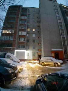 a parking lot with cars parked in front of a building at Accord24 Hostel in Yaroslavl