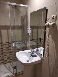 uma casa de banho com um lavatório e um chuveiro em Hostal Restaurante Cornella em Cornellà de Llobregat