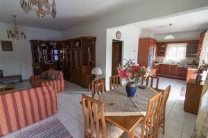 uma sala de jantar e sala de estar com uma mesa com flores em Big family house in Mesochoria village em Mesokhória