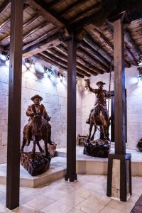 uma estátua de dois homens em cavalos num edifício em Casa de Reyes em Granada