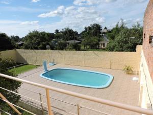 einen Pool auf einer Terrasse neben einem Zaun in der Unterkunft Rm Pousada Casa De Familia in São Gabriel