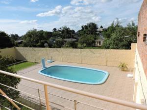 a swimming pool on a patio next to a fence at Rm Pousada Casa De Familia in São Gabriel