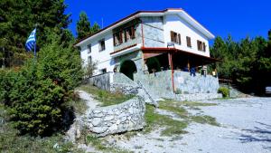 una casa en una colina con una bandera delante de ella en Koromilia refuge, en Díon