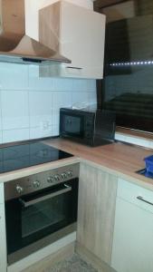 a kitchen with a stove and a microwave at Ferienwohnung Klaus in Oberhausen
