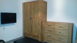 a wooden cabinet with a television on a wall at Ferienwohnung Klaus in Oberhausen