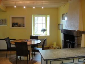 a dining room with a table and a fireplace at Moulin à Blé in Urville-Nacqueville +16 photos