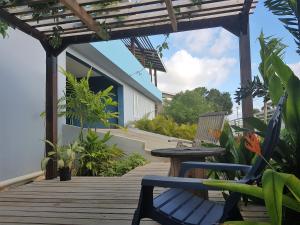una terraza de madera con un banco y una mesa en Guesthouse Curacao, en Willemstad