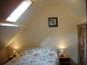 a attic bedroom with a bed and a skylight at Moulin à Blé in Urville-Nacqueville