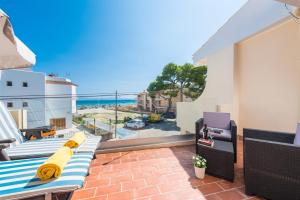 einen Balkon mit einem Sofa und Meerblick in der Unterkunft Encantador Dúplex Vacacional Reformado, Salzes 5, Frente a la Playa de Alcudia in Alcúdia