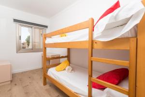 ein Etagenbettzimmer mit zwei Etagenbetten und einem Fenster in der Unterkunft Encantador Dúplex Vacacional Reformado, Salzes 5, Frente a la Playa de Alcudia in Alcúdia