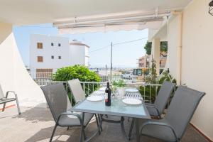 einen Tisch mit einer Flasche Wein auf dem Balkon in der Unterkunft Encantador Dúplex Vacacional Reformado, Salzes 5, Frente a la Playa de Alcudia in Alcúdia