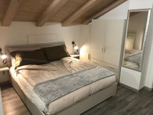 1 dormitorio con 1 cama grande y espejo en Baita Mattia, en Livigno