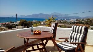 a table and two chairs with a bowl of fruit on a balcony at Theathina in Kalamaki Heraklion