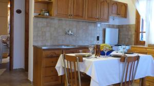 a kitchen with a table with a white table cloth at Theathina in Kalamaki Heraklion
