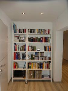 a book shelf filled with books in a room at Ferienwohnung Palme in Trofaiach