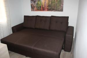 un sofá marrón en una habitación con una pintura en Duplex Belmaco - Casitas las Abuelas en Santa Cruz de la Palma