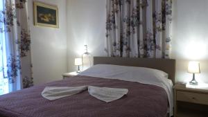 a bedroom with a bed with two lamps and curtains at Theathina in Kalamaki Heraklion
