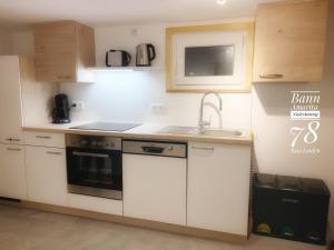 a kitchen with white cabinets and a sink and a stove at Ban Amarita in Laufen