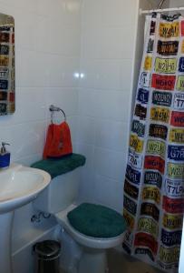 een badkamer met een toilet, een wastafel en een rode tas bij Desconectate departamento en Pucon in Pucón