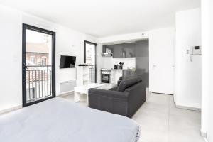 トゥールーズにある204 - Appartement Moderne et Lumineux - Jeanne d'Arc, Toulouseの白いベッドルーム(ベッド1台、ソファ付)