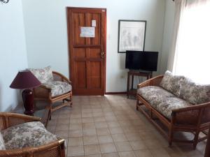a living room with chairs and a tv and a door at Cabañas y Departamentos Las Golondrinas in Coquimbo