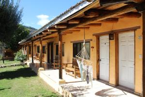 a house with two doors and a hammock outside at Hotel Paraiso del Oso in Cerocahu&iacute;