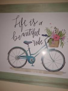Una foto de una bicicleta con un cartel que dice que la vida es un hermoso paseo en Las Calandrias en San Clemente del Tuyú