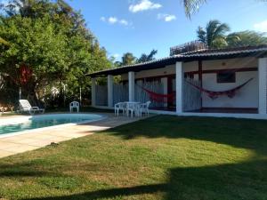 a villa with a swimming pool and a house at RANCHO GOSTOSO POUSADA in São Miguel do Gostoso