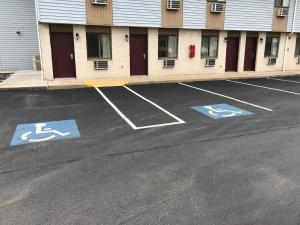 a parking lot with handicapped signs in a parking lot at Value Inn Harrisburg-York in Valley Green