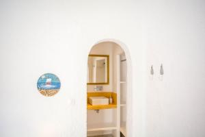 a bathroom with a sink and a mirror on a wall at Gorgona in Mylopotas