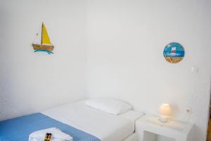 una piccola camera con un letto e una barca a vela sul muro di Gorgona a Mylopotas