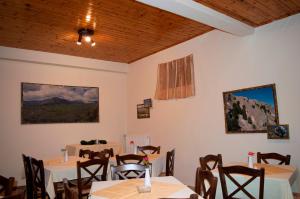 a restaurant with tables and chairs in a room at Xenon Achladokampos in Akhladhókambos