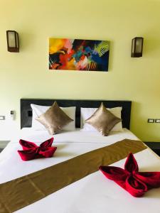 Lanta Amara Resort في كو لانتا: غرفة نوم بسريرين عليها بعرصي حمراء