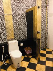 a bathroom with a toilet and a checkered floor at Lanta Amara Resort in Ko Lanta