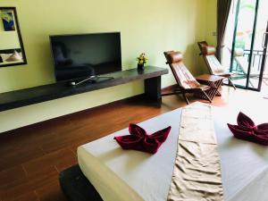 a living room with a tv and a couch with red bows at Lanta Amara Resort in Ko Lanta