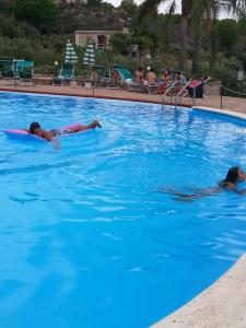 two people swimming in a swimming pool at Appartamento Rais Gerbi in Finale