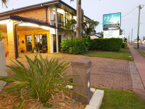 ein Gebäude mit einem Mülleimer vor einer Straße in der Unterkunft Miners Lodge Motor Inn in Mackay