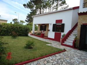 a house with red and white walls and a yard at Casa da LAGOA (Sesimbra) in Lagoa de Albufeira