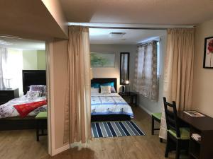 1 dormitorio con cama, escritorio y espejo en Self check-in spacious apartment with full Kitchen en Ottawa