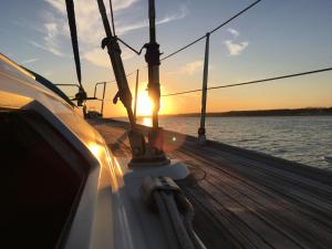 um barco com o pôr do sol na água em Veleiro Oceanico de 12 m em Lisboa